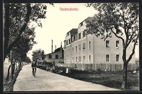 AK Neubrockwitz, Strassenpartie mit Fabrik und Radfahrer