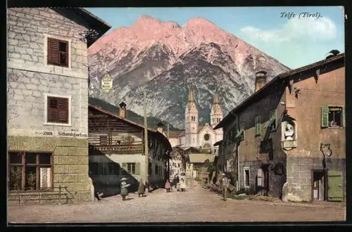 AK Telfs, Strassenkreuzung mit Gasthof Hohe Munde und Kirche gegen die Berge