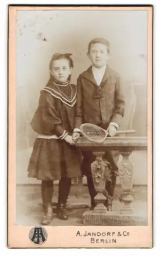 Fotografie A. Jandorf & Co., Berlin, Spittelmarkt 16/17, Kinder in eleganter Kleidung mit Tennisschläger