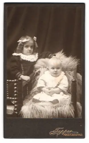Fotografie Tapper, Kristianstad, Zwei Kinder auf einem Stuhl mit Pelzdecke
