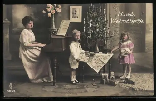 Foto-AK PFB Nr. 4166/5: Mutter sitzt am Klavier und Kinder betrachten ihre Geschenke, Herzliche Weihnachtsgrüsse