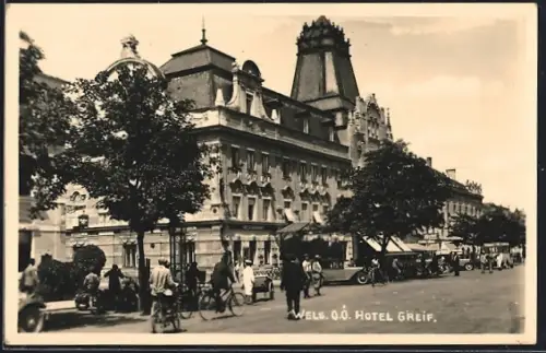 AK Wels /O.-Ö., Hotel Greif mit belebter Strasse, Radfahrer