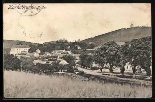 AK Karnabrunn, Ortsansicht von Feld aus mit Getreide auf Kirchturm
