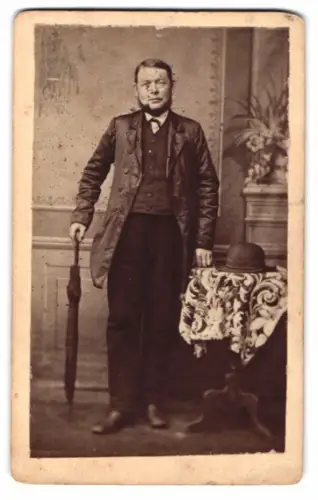 Fotografie unbekannter Fotograf und Ort, Mann mit Regenschirm und Melone