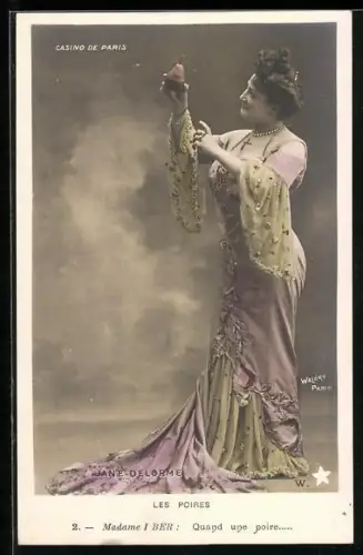 Foto-AK Walery, Paris: Jane Delorme in besticktem Kleid mit Schleppe zeigt auf Birne