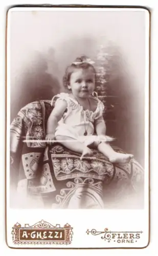 Fotografie A. Ghezzi, Flers /Orne, Rue de la Gare, Kleinkind auf kunstvoll gemustertem Sessel