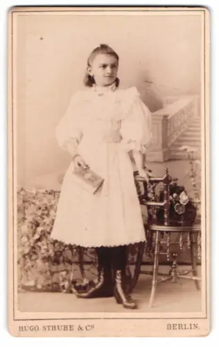 Fotografie Hugo Strube & Co., Berlin, Prinzesinnennstrasse 16, Mädchen mit Buch neben Stuhl