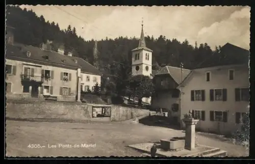 AK Les Ponts-de-Martel, Platz mit Brunnen, Mauer mit Schaukasten, Kirchturm