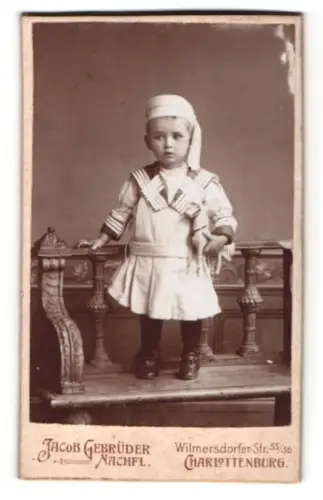 Fotografie Jacob Gebrüder Nachfl., Charlottenburg, Wilmersdorfer Str. 55/56, Kind in Matrosenanzug mit Pferdespielzeug