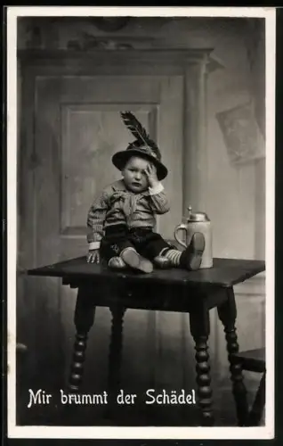 AK Kleiner Junge in Lederhosen, neben Bierkrug auf dem Tisch, Mir brummt der Schädel