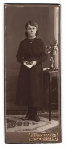 Fotografie Bernh. Franke, Spremberg, Mädchen mit Buch und Blumenvase