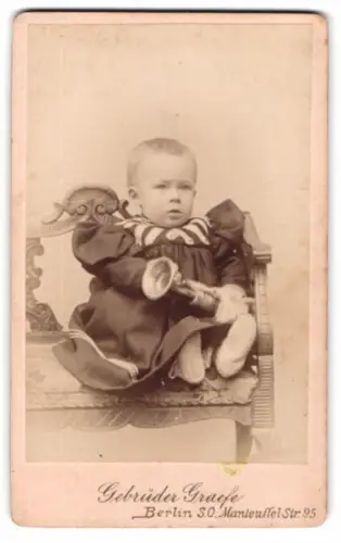 Fotografie Gebrüder Graefe, Berlin, Manteuffelstrasse 95, Portrait eines Kleinkinds mit Spielzeug