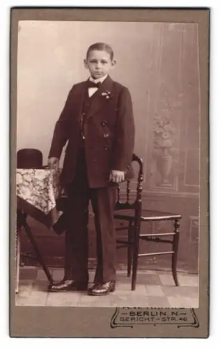 Fotografie A. W. Kraatz, Berlin, Gerichtstr. 46, Junger im Anzug neben Tisch