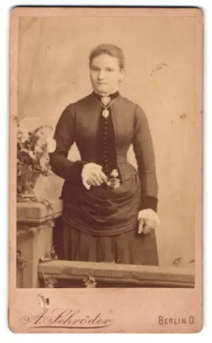 Fotografie A. Schröder, Berlin O., Gr. Frankfurterstr. 117, Frau im dunklen Kleid mit Blumenschmuck