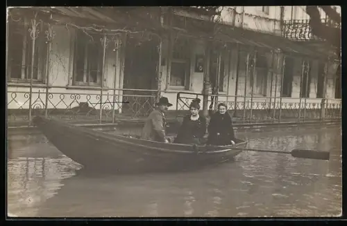 Foto-AK St. Goar, Hochwasser 1919- 1920, Drei Bewohner in einem Ruderboot