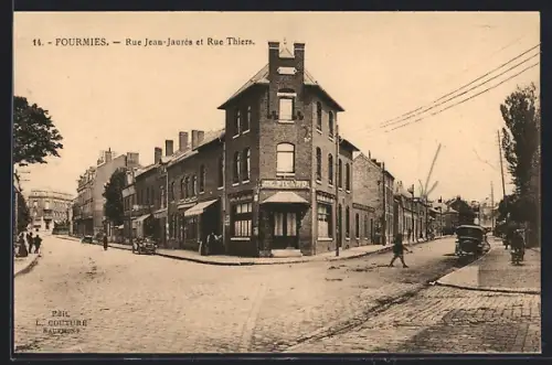 AK Fourmies, Rue Jean-Jaurès et Rue Thiers avec bâtiments en briques et carrefour animé