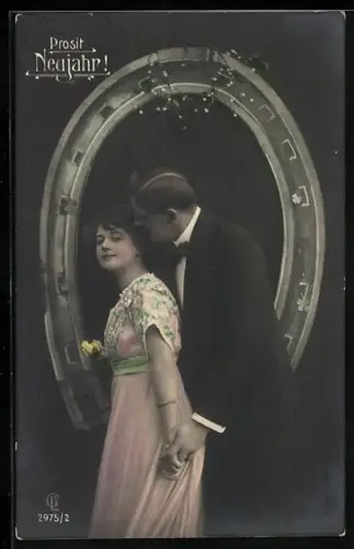 Foto-AK GL Co Nr. 2975/2: Liebespaar vor riesigem Hufeisen, Neujahrsgruss