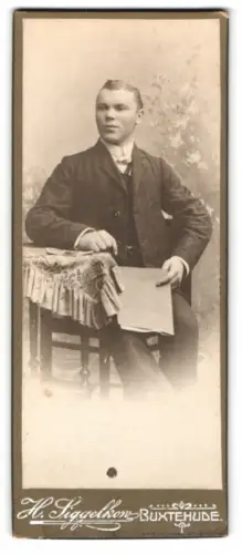Fotografie H. Siggelkow, Buxtehude, Sitzender Herr an einem Tisch