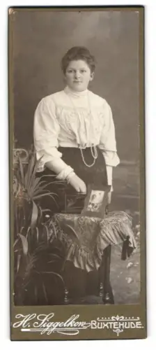 Fotografie H. Siggelkow, Buxtehude, Frau mit dekorativem Tisch