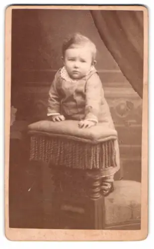 Fotografie Wilh. Rittner, Mühlberg a. E., Kind auf gepolstertem Stuhl