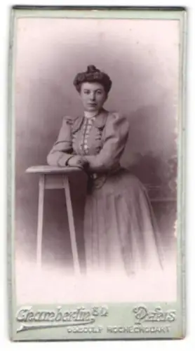 Fotografie Chamberlin, Paris, Boulevard Rochechouart 63, Frau im eleganten Kleid an einem Tisch