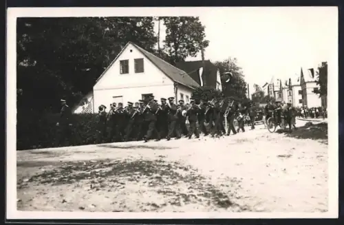 Foto-AK Chvalkovice, Militar-Musik-Parade auf einer Strasse, Haus mit Fahnen
