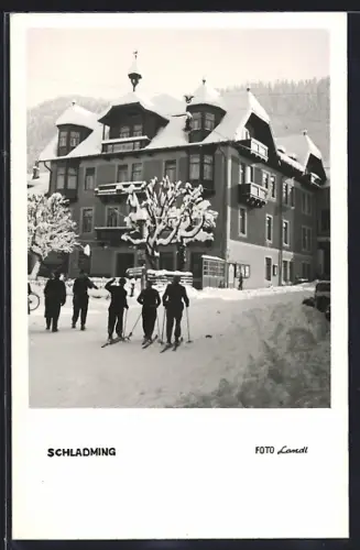 AK Schladming, Strassenpartie mit Eckgebäude und Skiläufern