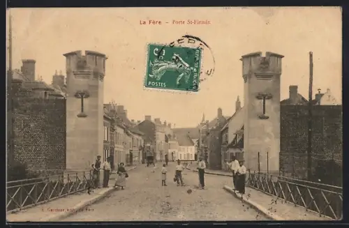 AK La Fère, Porte St-Firmin avec passants sur la rue principale