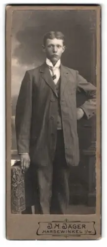 Fotografie J. H. Jäger, Harsewinkel i. W., Mann in Anzug vor dekorativem Hintergrund