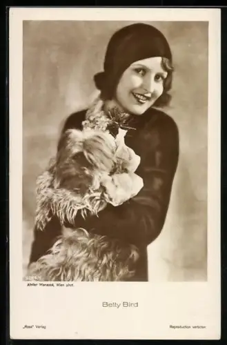 AK Schauspielerin Betty Bird, stehend im schwarzem Kostüm mit Hund auf dem Arm
