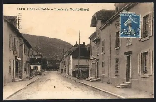 AK Pont de Roide, Route de Montbéliard avec vue sur la rue principale et les collines en arrière-plan