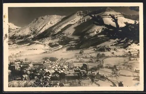 AK Villard-de-Lans, Vue générale du village enneigé et des montagnes majestueuses en arrière-plan