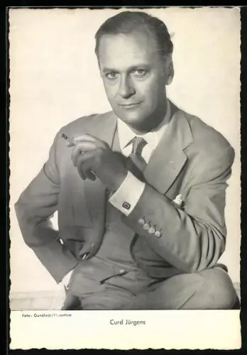 AK Schauspieler Curd Jürgens in elegantem Anzug mit einer Zigarette und überzeugendem Blick