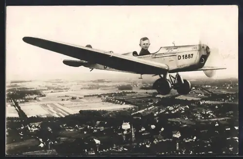 Foto-AK Knabe im Flugzeug über einer Stadt, Studiokulisse