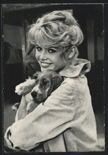 AK Schauspielerin Brigitte Bardot trägt eine helle Jacke und hält einen Hund auf dem Arm