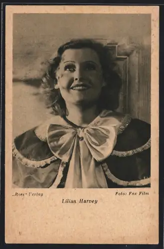 AK Schauspielerin Lilian Harvey trägt Umhang mit Schleife