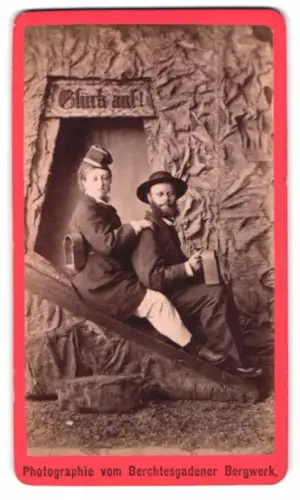 Fotografie Fotograf unbekannt, Berchtesgaden, Besucher des Salzbergwerk als Bergleute auf Rutsche, Studiokulisse