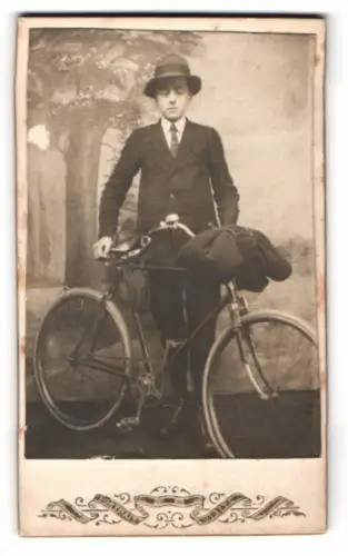 Fotografie junger Mann mit seinem Fahrrad vor einer Studiokulisse 1919