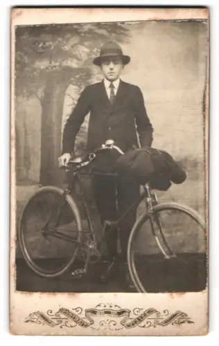 Fotografie junger Mann mit seinem Fahrrad samt Decke vor einer Studiokulisse