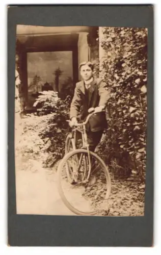 Fotografie Junge mit seinem Fahrrad im Garten