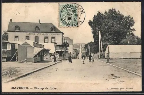 AK Mayenne, Champ de foire avec stands et passants