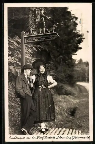 AK Schramberg /Schwarzwald, Trachtenpaar aus der Fünftälerstadt an einem Wegweiser