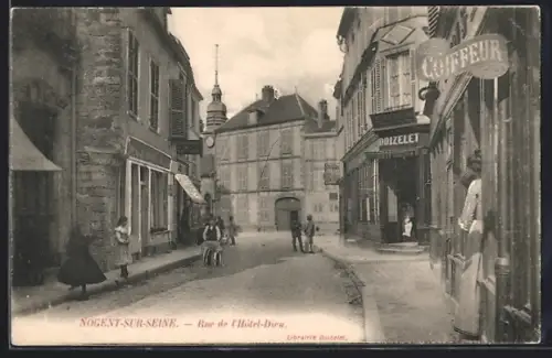 AK Nogent-sur-Seine, Rue de l`Hôtel-Dieu avec passants et boutiques