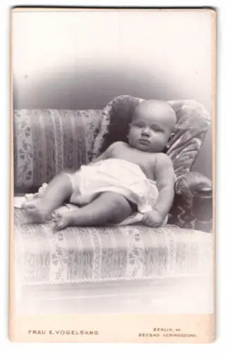 Fotografie Frau E. Vogelsang, Berlin, Leipziger Strasse 106, Porträt eines Babys auf einem Sofa