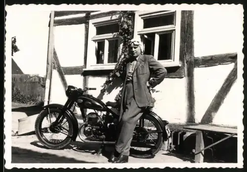 Fotografie Motorrad Zündapp, Kradfahrer mit Haube vor Fachwerkhaus stehend