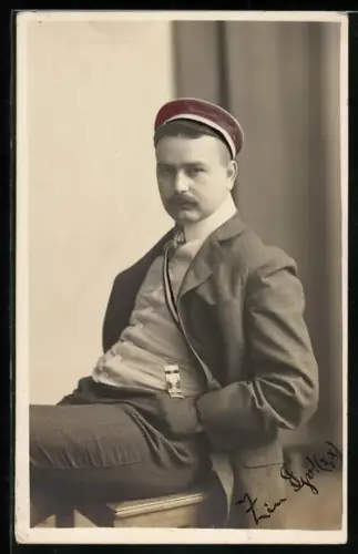 Foto-AK Student sitzt auf einem Hocker, studentische Szene