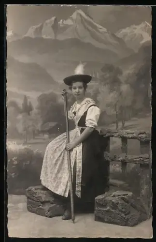 Foto-AK Trachtenmädchen mit Wanderstock vor Bergkulisse, 1920