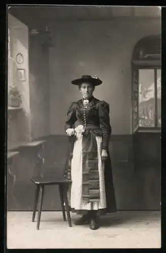 AK Berchtesgaden, Berchtesgadnerin in Tracht in Stube mit Ausblick