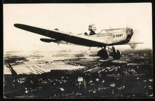 Foto-AK Mädchen im Cockpit eines einmotorigen Tiefdecker-Flugzeuges im Fluge, Studiokulisse