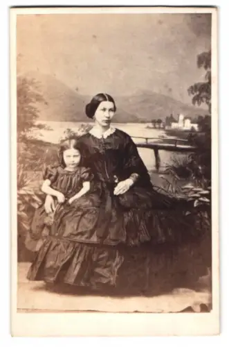 Fotografie Portrait junge Mutter mit ihrer Tochter vor einer gemalten Studiokulisse